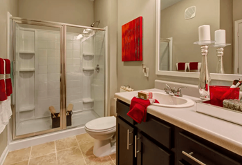 Bathroom, tile flooring, shower, toilet, vanity with solid surface countertops